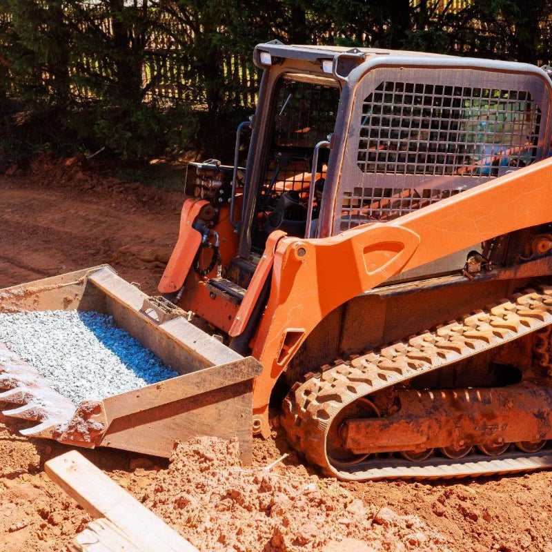 Skid steer using rubber tracks on construction site